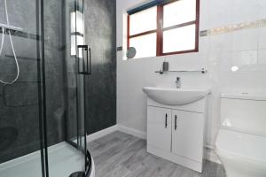 a bathroom with a sink and a shower at WATERSIDE cottage in Wadebridge