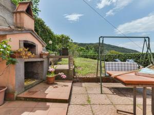 a patio with a fireplace and a table and a swing at Holiday Home La Paradisa by Interhome in Nisporto