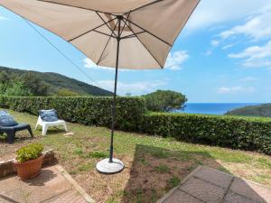 an umbrella sitting next to a chair and a table at Holiday Home La Paradisa by Interhome in Nisporto