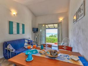 a living room with a table and a blue couch at Holiday Home La Paradisa by Interhome in Nisporto