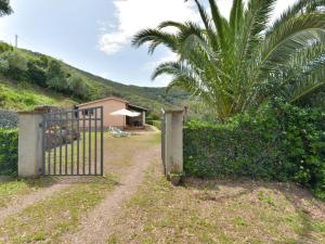 a gate leading to a house with a palm tree at Holiday Home La Paradisa by Interhome in Nisporto