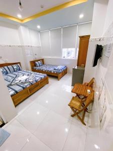 a room with two beds and a tv in it at Hotel thanh vinh in Ho Chi Minh City