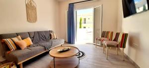 uma sala de estar com um sofá, uma mesa e cadeiras em The Central Villa - Kassiopi Corfu Villas em Kassiopi