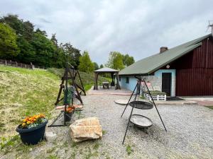a swing set and a playground with a barn at Świętokrzyska Chata Biegacza in Nowa Słupia