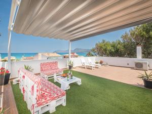 eine Terrasse mit roten und weißen Möbeln und Meerblick in der Unterkunft Apartment Misefo by Interhome in Son Serra de Marina