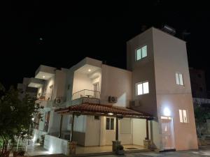 een groot wit gebouw 's nachts bij Villa Family Garden in Ksamil
