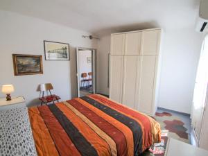 a bedroom with a bed with a striped comforter at Apartment Casa Centrale by Interhome in Moneglia