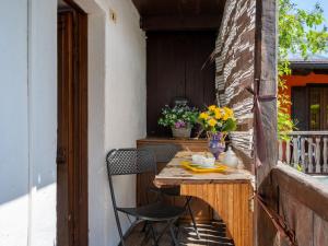 una mesa y sillas al aire libre en un balcón con una mesa y flores en Apartment Ardene - MCG451 by Interhome en Vigino