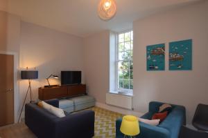 a living room with two blue couches and a window at Beautiful flat in luxury Graylingwell development in Chichester