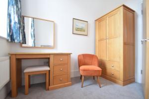a bedroom with a desk and a chair and a dresser at Beautiful flat in luxury Graylingwell development in Chichester