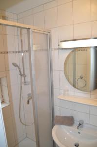 un bagno con doccia, lavandino e specchio di Hotel Südstrand Amrum a Wittdün Altre 25 foto