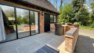 a patio with a table and chairs and a building at Elegant peaceful barn in rural village setting close to Stratford upon Avon in Stratford-upon-Avon