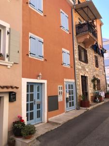 a building with blue doors and windows on a street at Romantic studio old town in Vrsar