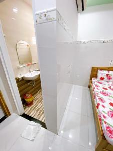 uma pequena casa de banho com uma cama e um lavatório em Hotel thanh vinh em Ho Chi Minh