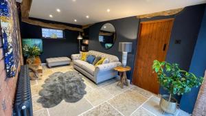 a living room with a couch and a mirror at Elegant peaceful barn in rural village setting close to Stratford upon Avon in Stratford-upon-Avon