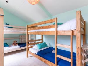 メルヴィル・フランスヴィル・プラージュにあるHoliday Home Villa Hélios by Interhomeの青い壁の客室で、二段ベッド2台が備わります。