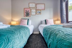 two beds sitting next to each other in a room at Close to A46 City Centre Sleeps 6, 5 Beds Ensuite FREE Wi-Fi Queens House Inspire Homes in Parkside