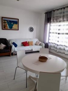 a living room with a white table and chairs at Belamandil Garden ,family holidays ,caminho do torrejao olhao in Olhão