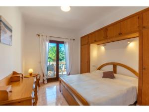 Un dormitorio con una cama grande y un escritorio. en Apartment Bella Vista by Interhome, en Cala Santanyi