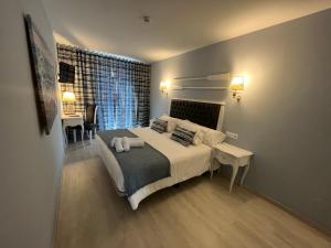 a bedroom with a bed and a table and a window at Hotel Boutique Arha Villa de Santona in Santoña +40 photos
