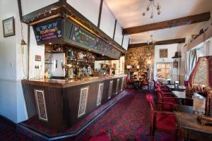 a bar in a pub with chairs and tables at Tankerville Arms Hotel in Wooler