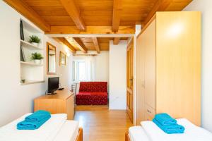 um quarto com duas camas e uma cadeira vermelha em Foteza Apartments em Dubrovnik