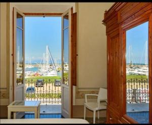 een open deur naar een balkon met uitzicht op een haven bij Villino Ermione in Marina di Pisa