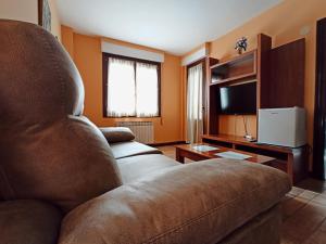 - un salon avec un canapé et une télévision dans l'établissement La Granja De Vitoria, à Hueto Arriba