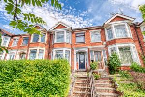 an orange brick house with white windows and bushes at Close to A46 City Centre Sleeps 6, 5 Beds Ensuite FREE Wi-Fi Queens House Inspire Homes in Parkside