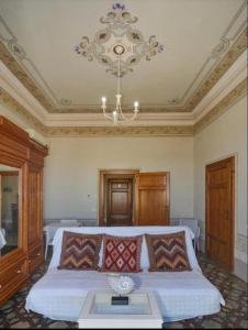 a bedroom with a large bed with a chandelier at Villino Ermione in Marina di Pisa