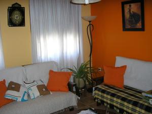 a living room with a couch and orange walls at Casa de La Paca in Coca