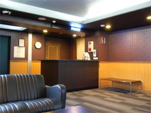 a waiting room with a couch and a bar at HOTEL LiVEMAX BUDGET Nagoya in Nagoya