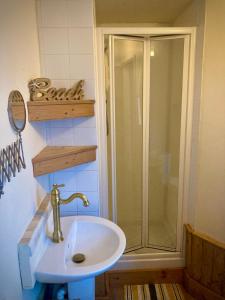 uma casa de banho com um chuveiro e um lavatório. em Aqua Shack at Pure Shores Retreats em Newquay