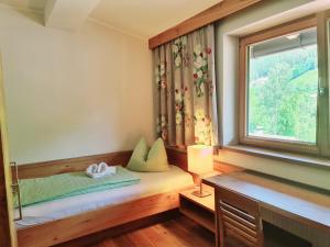 Bett in einem Zimmer mit Fenster in der Unterkunft Hotel Giessenbach in Fügen