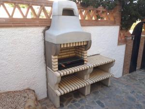 un horno de pizza sentado en un banco junto a una pared en Villa Mondriana, en Mondrón