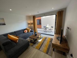 een woonkamer met een bank en een tv bij 2 Putsborough - Luxury Apartment at Byron Woolacombe, only 4 minute walk to Woolacombe Beach! in Woolacombe