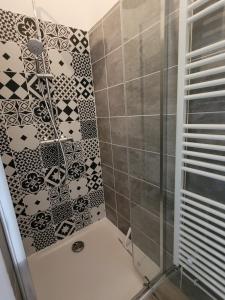 a bathroom with a shower with black and white tiles at La Terrasse d'Onna in Theneuil +16 photos