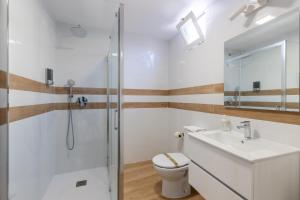 a bathroom with a shower and a toilet and a sink at HOMEABOUT LA MERCED Apartments in Málaga