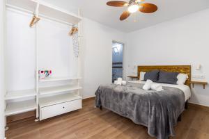 1 dormitorio con 1 cama y ventilador de techo en HOMEABOUT LA MERCED Apartments, en Málaga