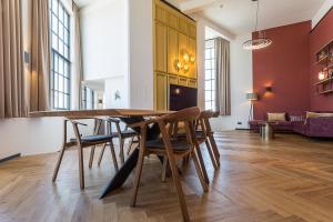 a dining room with a wooden table and chairs at Hotel de Timmerfabriek I Kloeg Collection in Vlissingen