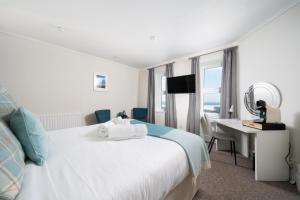 a bedroom with a bed and a desk with a computer at The Land's End Hotel in Sennen