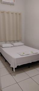 a bed in a room with a white floor at Hotel Vale do Sol in Votuporanga