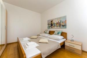 een slaapkamer met twee bedden en een schilderij aan de muur bij Summer Breeze Pool Apartments in Novalja