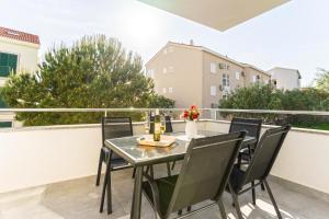 a table and chairs on the balcony of a apartment at Summer Breeze Pool Apartments in Novalja