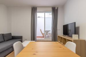 a living room with a couch and a table with a television at HOMEABOUT LA MERCED Studios in Málaga