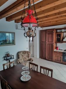 uma sala de jantar com uma mesa e um lustre em Casa sul Cielo di Burano em Burano