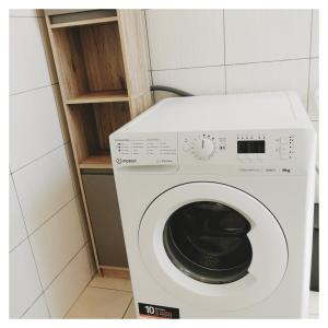 eine weiße Waschmaschine in einem kleinen Zimmer in der Unterkunft L'opale in Le Bourg-dʼOisans