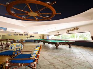 a pool table in a room with chairs and a wheel at Hotel Soleil Pacifico in Chulamar