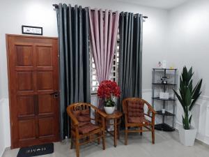 a room with a table and two chairs and a window at Homestay Qaseh Kerteh in Kertih +3 photos