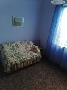 un sofá sentado en una habitación azul con cortinas en Дом под ключ en Gagra